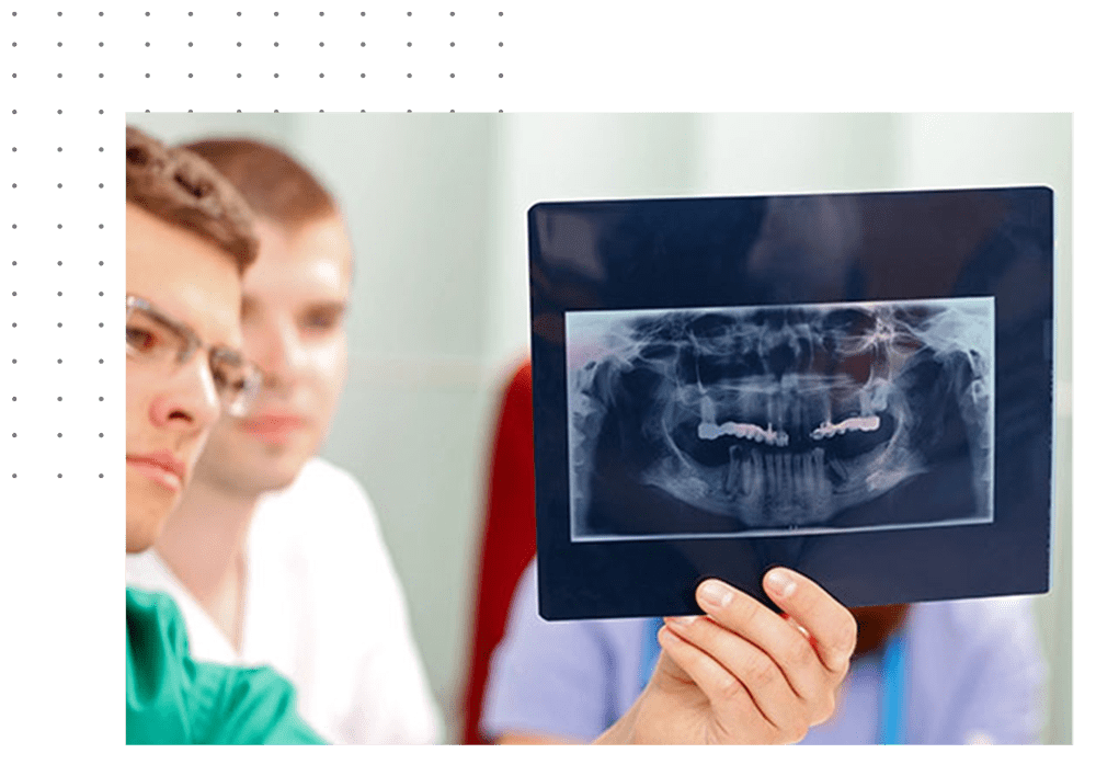 A dentist holding up an x-ray of teeth.