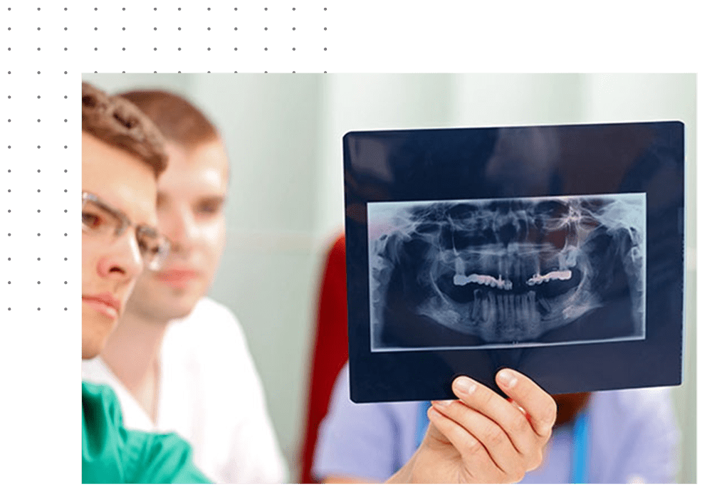 A dentist holding up an x-ray of teeth.